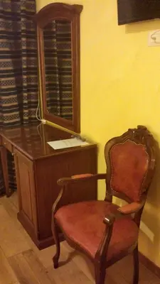 a chair sitting next to a desk with a mirror at Pitagora House in Rome