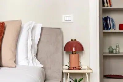 a red lamp on a side table next to a couch at Casa Gracchi by Hili in Rome