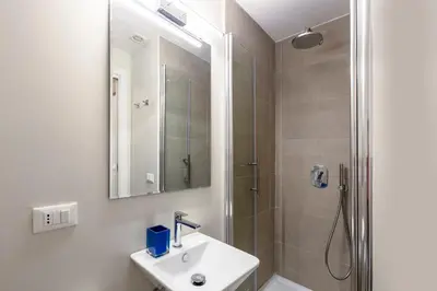 a bathroom with a sink and a shower with a mirror at Casa Gracchi by Hili in Rome