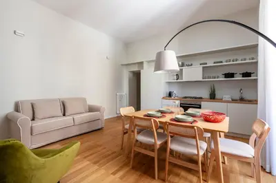 a living room with a table and chairs and a couch at Casa Gracchi by Hili in Rome