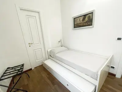 a white room with a bed with a picture on the wall at DeLUX Apartment in Rome