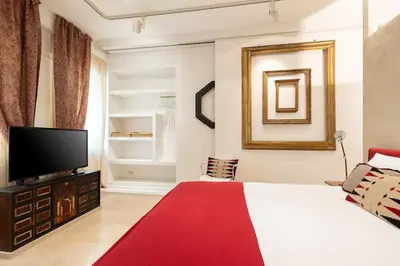 a bedroom with a bed and a flat screen tv at Luxurious home of the antiquarian at Spanish Steps in Rome