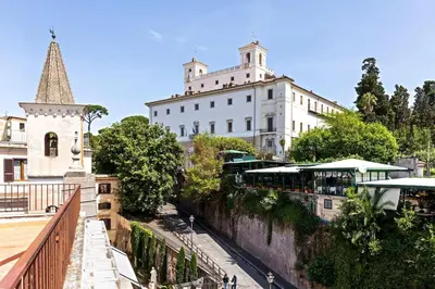 a large white building with a clock tower next to a street at Luxurious home of the antiquarian at Spanish Steps in Rome