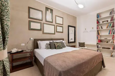 a bedroom with a bed and a book shelf at Luxurious home of the antiquarian at Spanish Steps in Rome