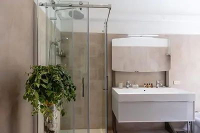 a bathroom with a sink and a glass shower at Luxurious home of the antiquarian at Spanish Steps in Rome