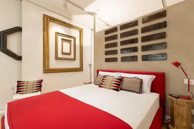 a bedroom with a red and white bed in a room at Luxurious home of the antiquarian at Spanish Steps in Rome