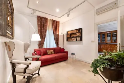 a living room with a red couch and a chair at Luxurious home of the antiquarian at Spanish Steps in Rome