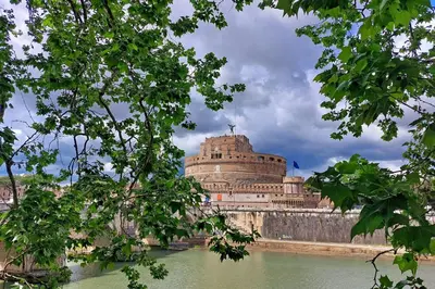 a large building sitting on the side of a river at Magical Navona Duplex With Terrace by Halldis in Rome