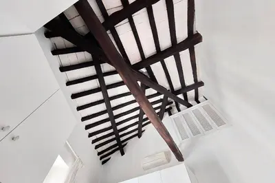 an overhead view of a wooden spiral staircase at Magical Navona Duplex With Terrace by Halldis in Rome
