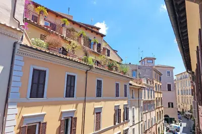a building with flowers on the balconies on a street at Magical Navona Duplex With Terrace by Halldis in Rome