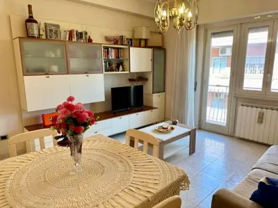 a living room with a table with a vase of flowers on it at Capa's Boccea in Rome