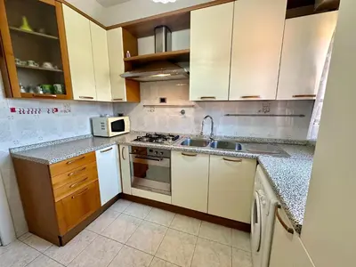 a kitchen with white cabinets and a sink and a microwave at Capa's Boccea in Rome