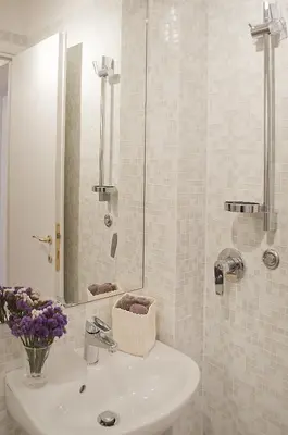 a white bathroom with a sink and a mirror at Borgo Pio 51 Apartment Vatican in Rome