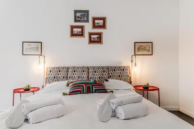 a bedroom with a large white bed with two tables at Sales in Trastevere in Rome