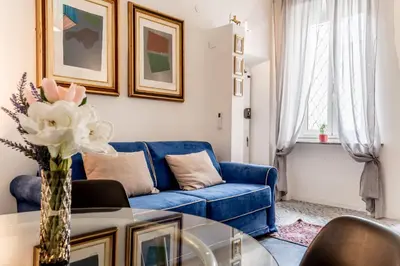 a living room with a blue couch and a table at Sales in Trastevere in Rome