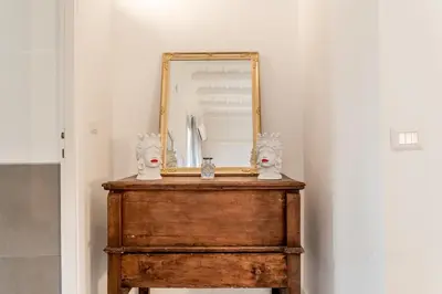 a mirror sitting on top of a wooden dresser at Sales in Trastevere in Rome
