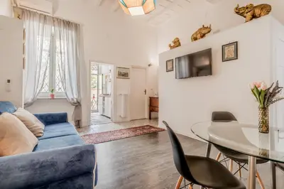 a living room with a blue couch and a glass table at Sales in Trastevere in Rome