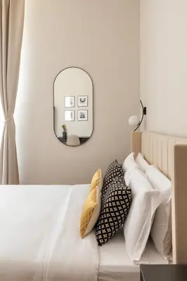 a bedroom with a bed with pillows and a mirror at Candia Boutique Apartment in Rome