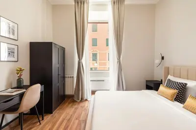 a bedroom with a bed and a desk and a window at Candia Boutique Apartment in Rome