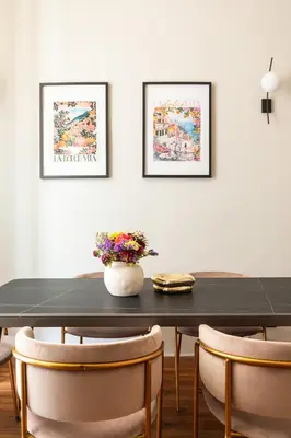 a black dining room table with chairs and a vase of flowers at Candia Boutique Apartment in Rome