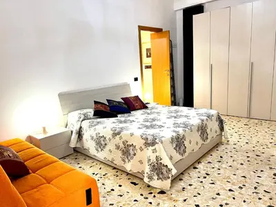 a bedroom with a bed and a orange couch at New House in Rome