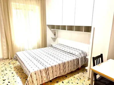 a bedroom with a bed and a table and a window at New House in Rome