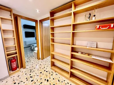 a walk in closet with wooden shelves at New House in Rome