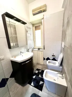 a bathroom with a sink and a toilet and a mirror at New House in Rome