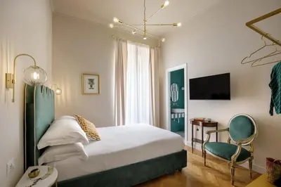 a bedroom with a bed and a chair and a television at Daplace - Lucilla Apartment in Rome