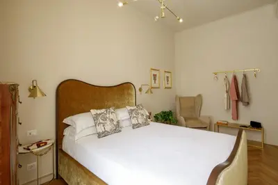 a bedroom with a white bed with a wooden headboard at Daplace - Lucilla Apartment in Rome