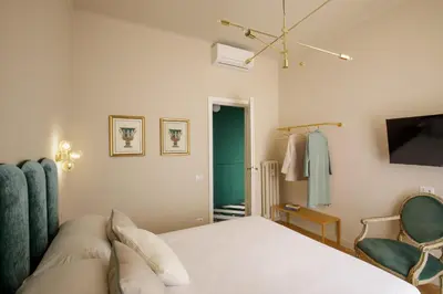 a bedroom with a bed and a tv and a chair at Daplace - Lucilla Apartment in Rome