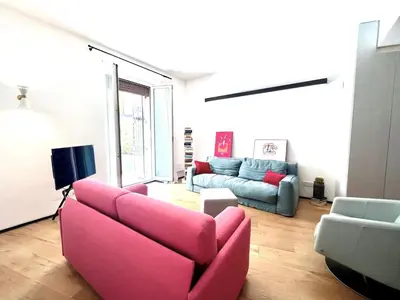 a living room with a pink couch and a tv at The Garden in Parioli in Rome