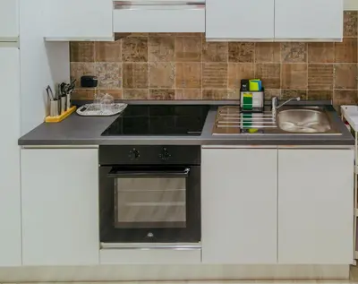a kitchen with a sink and a stove at La casa di Nonna Peppina a Trastevere in Rome