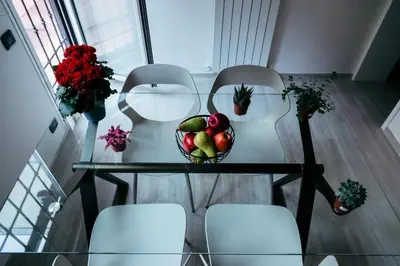 a bowl of fruit on a glass table with chairs at La casa di Nonna Peppina a Trastevere in Rome