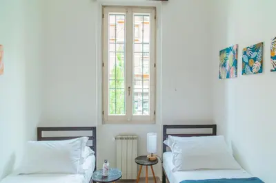 a bedroom with two beds and a window at La casa di Nonna Peppina a Trastevere in Rome