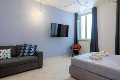 a living room with a couch and a tv on a wall at HB Montebello apartment in Rome