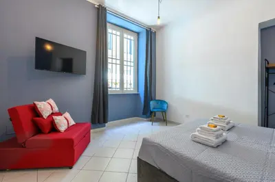 a bedroom with a red couch and a red chair at HB Montebello apartment in Rome