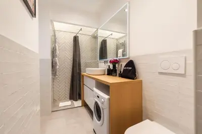 a bathroom with a washing machine and a mirror at Trevi Fountain Boutique Apartment in Rome