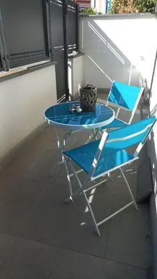 a blue table and a chair on a balcony at Viktoria's Suite Rome Center in Rome