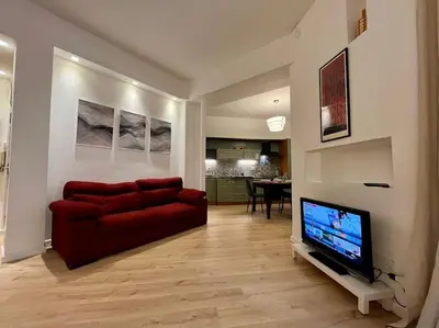 a living room with a red couch and a flat screen tv at Appartamento con giardino tra San Pietro e Stadio Olimpico Roma in Rome