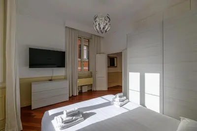 a bedroom with a white bed and a television at City Center Apartment - Pantheon in Rome