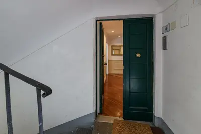 an empty hallway with a green door and a stairway at City Center Apartment - Pantheon in Rome