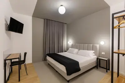 a bedroom with a bed and a table and a desk at Luciano Queen's Guest House in Rome
