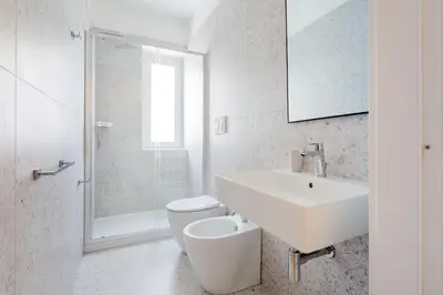 a white bathroom with a sink and a toilet at Luciano Queen's Guest House in Rome