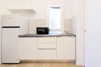 a kitchen with white cabinets and a window at Luciano Queen's Guest House in Rome