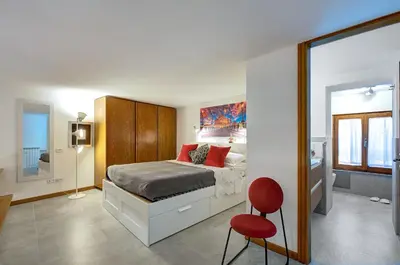 a bedroom with a bed and a red chair at Dimora dell'Orso in Rome