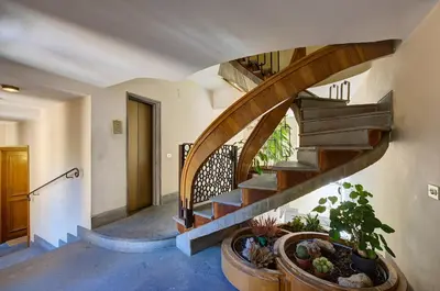 a hallway with a spiral staircase with potted plants at Dimora dell'Orso in Rome