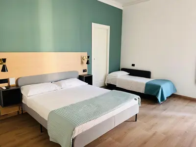 two beds in a room with blue walls at My Maison Italy GuestHouse in Rome