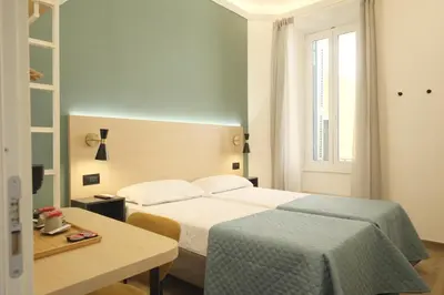 a hotel room with two beds and a table at My Maison Italy GuestHouse in Rome