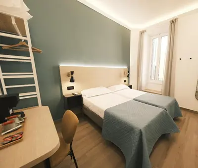 a bedroom with a bed and a desk and a ladder at My Maison Italy GuestHouse in Rome